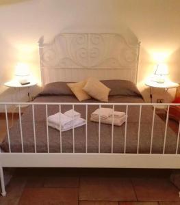 ein weißes Bett mit zwei Lampen an zwei Tischen in der Unterkunft Casa Rustikò in Marsala