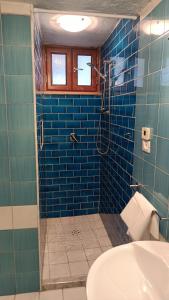 bagno piastrellato blu con doccia e lavandino di Suite Giulia a Ischia
