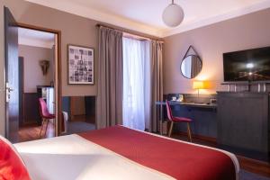 パリにあるジョルジュ サンのベッドとデスクが備わるホテルルームです。