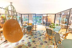 a restaurant with tables and chairs and glass walls at ibis Styles Paris 16 Boulogne in Paris +37 photos