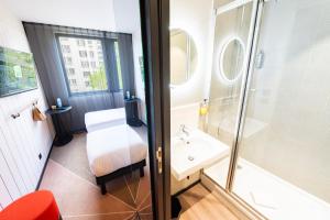 La salle de bains est pourvue d'une douche et d'un lavabo. dans l'établissement ibis Styles Paris 16 Boulogne, à Paris