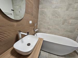 a bathroom with a white tub and a sink at Oasului Residence in Cluj-Napoca