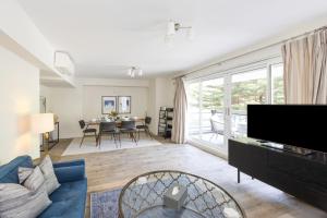 a living room with a blue couch and a tv at Buckingham & Lloyds in London