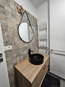 a bathroom with a sink and a mirror at Oasului Residence in Cluj-Napoca