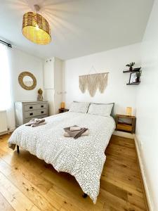 a white bedroom with a large bed with two dishes on it at Minimalistic apartment in Crystal Palace in Crystal Palace