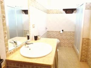 ein Badezimmer mit einem weißen Waschbecken und einem WC in der Unterkunft Casa Rustikò in Marsala