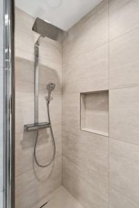 uma casa de banho com uma cabeça de chuveiro em Luxury Ville Haute Haven Queen Bed & City Views em Luxemburgo