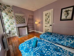 1 Schlafzimmer mit 2 blauen Betten und einem Kamin in der Unterkunft Hotel particulier 200m2 plein centre et plage - 2 à 25 personnes in Dieppe