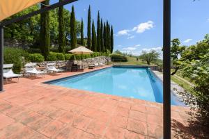 una piscina con patio e alberi di Villa Cavallari a Radda in Chianti