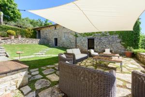 拉達因基安蒂的住宿－Villa Cavallari，庭院配有遮阳伞、椅子和桌子。