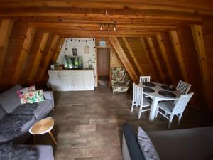 salon ze stołem i krzesłami w kabinie w obiekcie Wakacyjna BRDA w Rowach w Rowach
