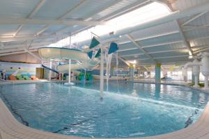 a indoor swimming pool with a water slide at Presthaven sands P&Ts home from home in Talacre