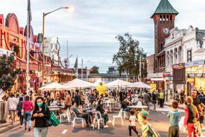 Une foule de gens marchant dans une rue avec une tour d'horloge dans l'établissement MetaWise Burwood Westfield Cozy 2Bed Free Parking VT108, à Sydney