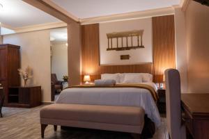 a bedroom with a large bed with a bench in it at Luna de Plata in Quetzaltenango