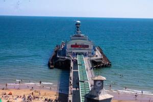 a pier on a beach with people on the beach at Student Only Ensuite Rooms Zeni Bournemouth in Bournemouth