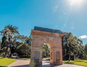 a stone arch in a park with palm trees at MetaWise Burwood Westfield Cozy 2Bed Free Parking VT109 in Sydney