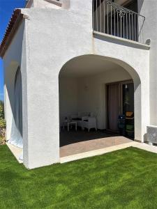 Casa blanca con patio y césped verde en Endless Summer Apartment en Olbia