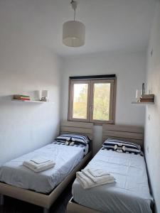 2 camas en una habitación con ventana en Endless Summer Apartment en Olbia
