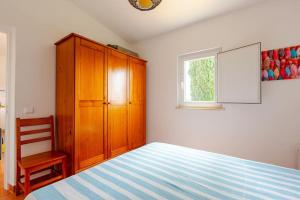 a bedroom with a bed and a wooden cabinet and a window at Casa Azul Beach and countryside in Armação de Pêra