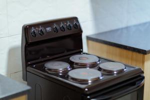 a black stove top oven in a kitchen at Epignosis Apartments in Lusaka