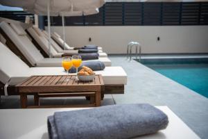 a pool with a table and two glasses of orange juice at Villa Linea Verde II by Sealand Villas in Tsilivi