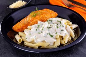 a black bowl of pasta with salmon and sauce at Point Motel 2 in São José dos Campos