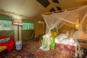 una camera con letto a baldacchino in una tenda. di Wielewaal Bush Lodge a Marloth Park