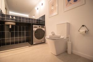 a bathroom with a washing machine and a toilet at Breathe Apartments by Concept Flats in Valencia
