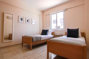 a bedroom with two beds and a window at Phaedrus Living: Universal City Flat Alina in Paphos City