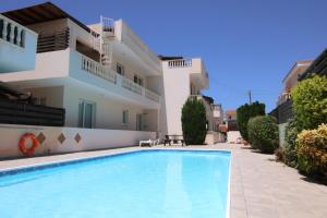 a swimming pool in front of a building at Phaedrus Living: Universal City Flat Alina in Paphos City
