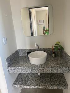 a sink in a bathroom with a mirror at Apartamento na Batista Campos 02 quartos in Belém