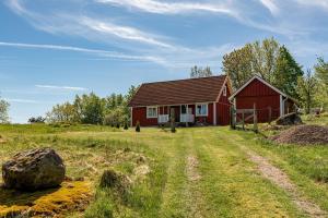 um celeiro vermelho no meio de um campo em Holiday accommodation with great nature experience near Laholm em Knäred