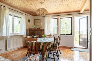 uma sala de jantar com mesa, cadeiras e janelas em Holiday accommodation with great nature experience near Laholm em Knäred