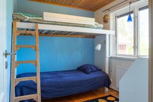 um quarto com um beliche e uma parede azul em Holiday accommodation with great nature experience near Laholm em Knäred