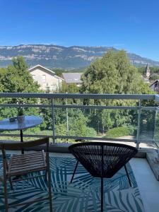 d'une terrasse avec une table et des chaises sur un balcon. dans l'établissement Entre lac et montagnes 47m², au Bourget-du-Lac