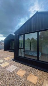 un edificio negro con grandes ventanas de cristal en el suelo en Deerpark luxury 3 bed retreat, en Cashel