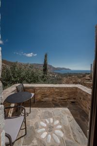 eine Terrasse mit einem Tisch, Stühlen und Meerblick in der Unterkunft Alika Resort in Álika