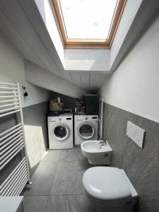 uma casa de banho com um WC e uma máquina de lavar e secar roupa em Casa P em Malgrate