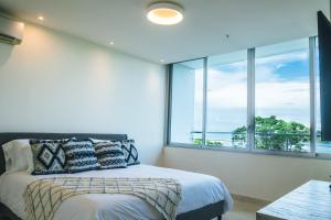 1 dormitorio con cama y ventana grande en Oceanview Apt Near Panama City w/ King Bed & More, en Playa Bonita Village