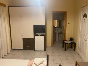 a room with a kitchen with a tv and a counter at Corali in Menídion