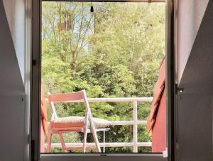 a chair sitting on a balcony looking out of a window at El Solsticio - 30601 in Somo