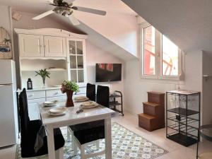 a kitchen and dining room with a table and a ceiling fan at El Solsticio - 30601 in Somo