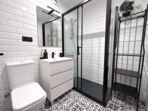 a bathroom with a toilet and a sink and a shower at El Solsticio - 30601 in Somo +2 photos