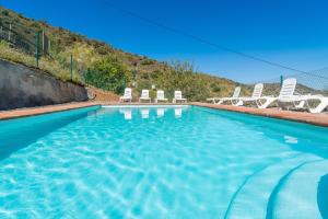 a swimming pool with lounge chairs at Complejo Rural El Mirador in Málaga