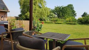 a patio with a table and chairs and a yard at B&B Herberg Boerenhol in Poperinge