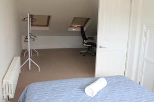 Cette chambre comprend un lit, un bureau et une chaise. dans l'établissement City Reach Retreat Spacious 4Bed House Startford Maryland Great Transport Links, à Londres