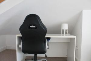 a black office chair sitting next to a white desk at City Reach Retreat Spacious 4Bed House Startford Maryland Great Transport Links in London
