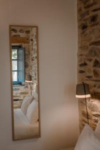 a mirror in a bedroom with a bed and lamps at Alika Resort in Álika