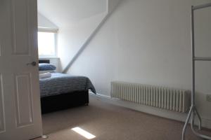a small bedroom with a bed and a window at City Reach Retreat Spacious 4Bed House Startford Maryland Great Transport Links in London