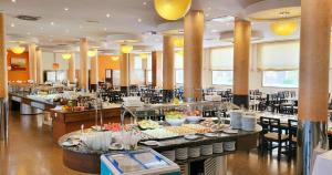 un buffet avec des plats exposés dans un restaurant dans l'établissement Hotel Monarque Costa Narejos, à Los Alcázares